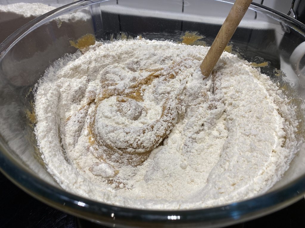 Adding flour to the peanut butter cookie dough