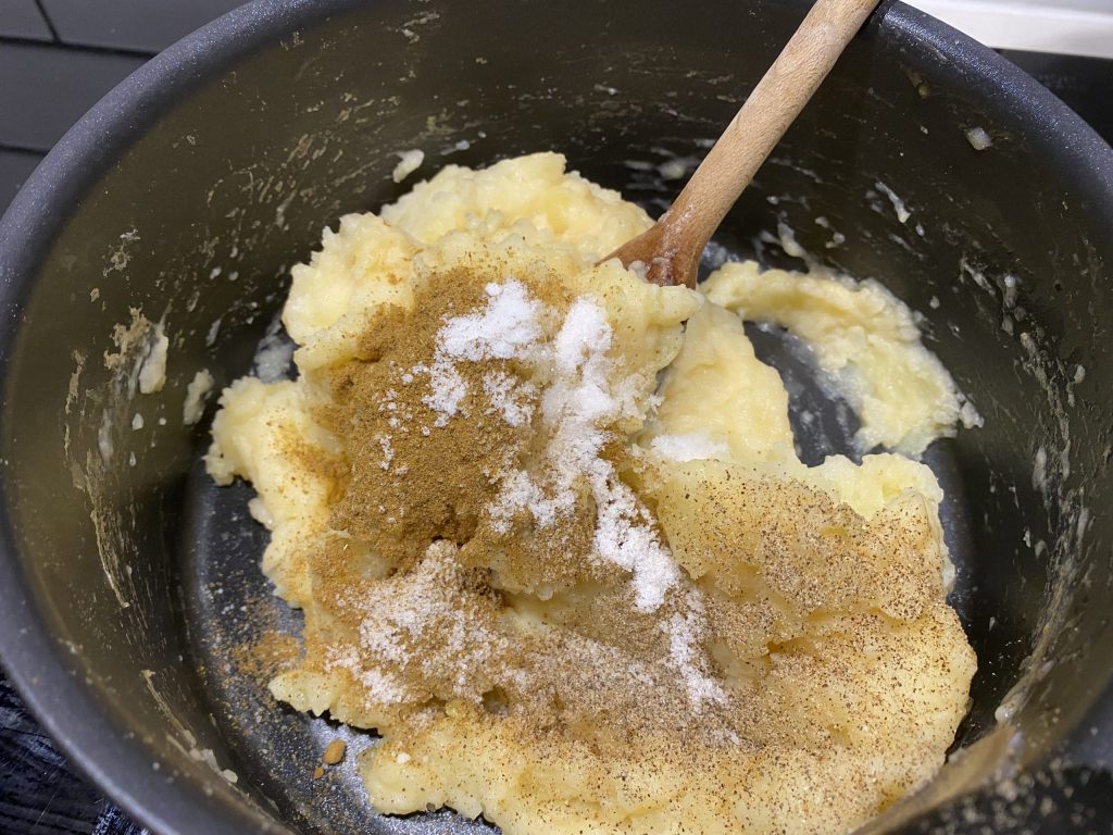 Adding spices to the mashed potatoes