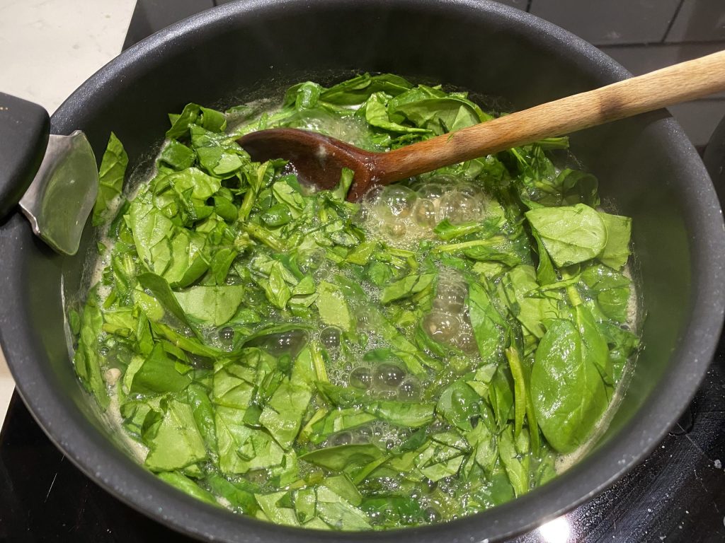 Adding the chopped spinach to the Okra Sauce