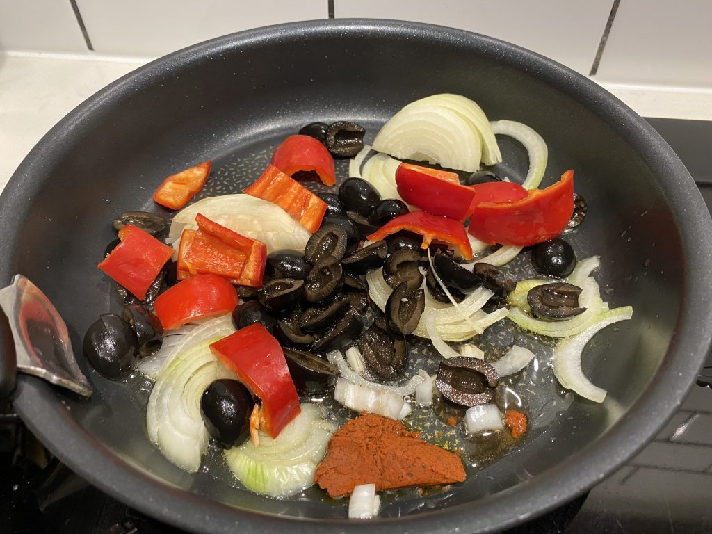Frying the onions, pepper, olives and achiote