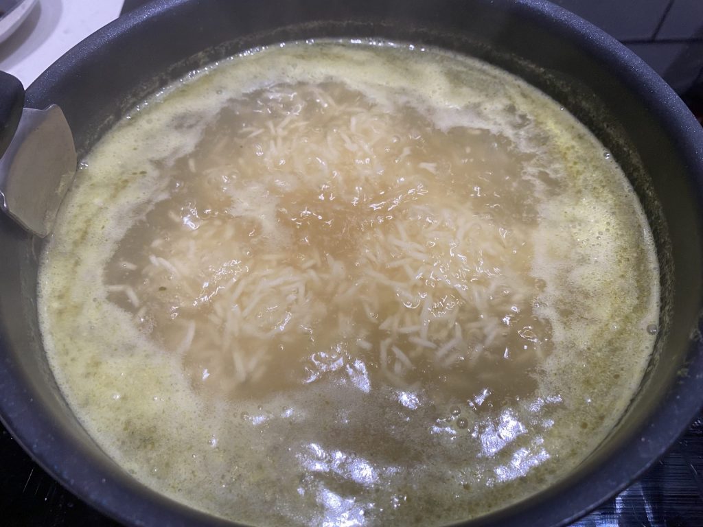 Cook rice in the boiling bouillon