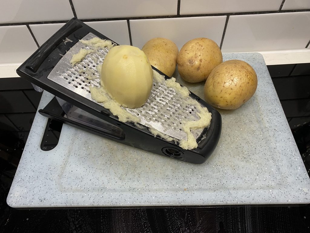 Finely grating the potatoes