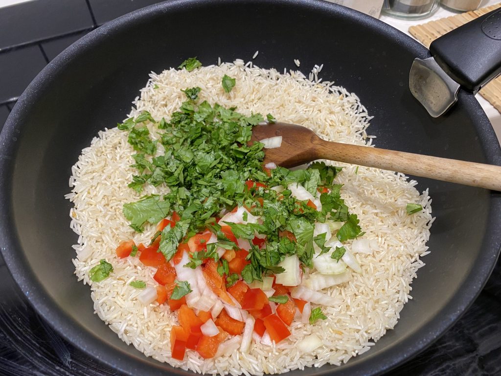 Sautéing rice with some onion, pepper and cilantro