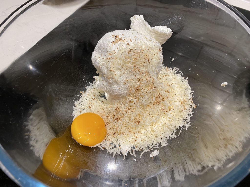 Add parmesan, egg yolk and seasoning to the drained ricotta