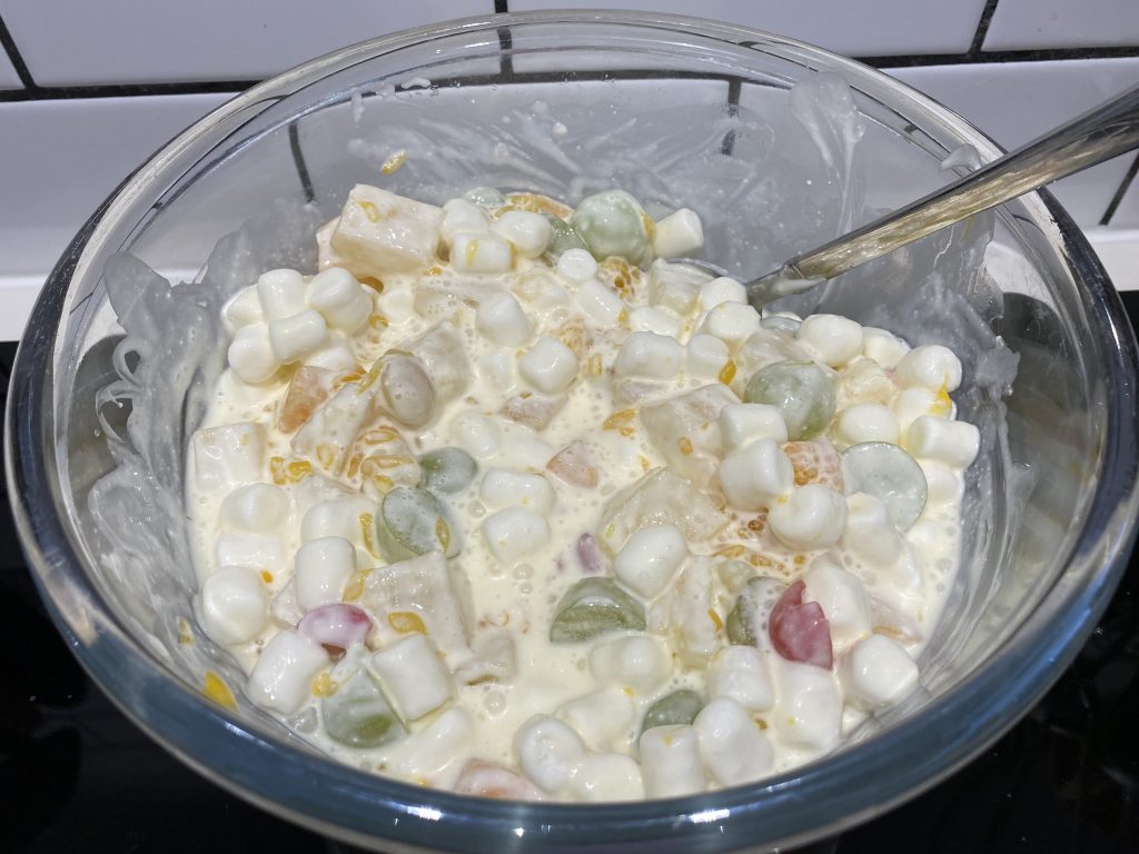 Mix fruit with soured cream and marshmallows